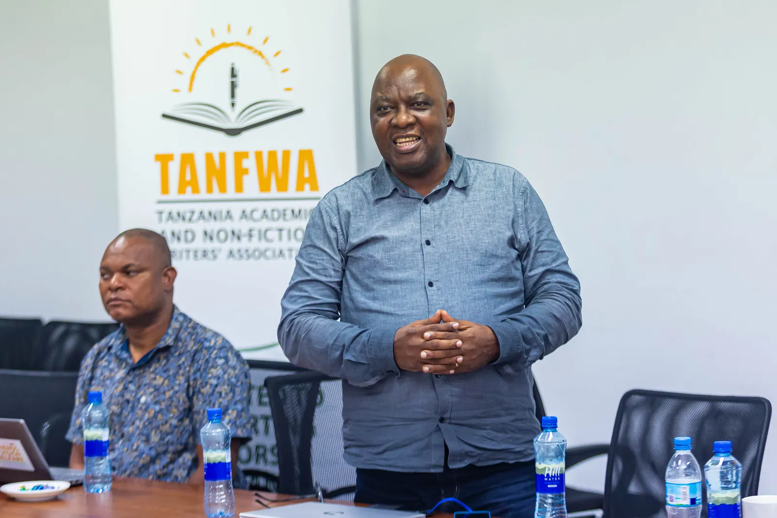 Delegates applauding a contribution, with the TANFWA banner on the wall