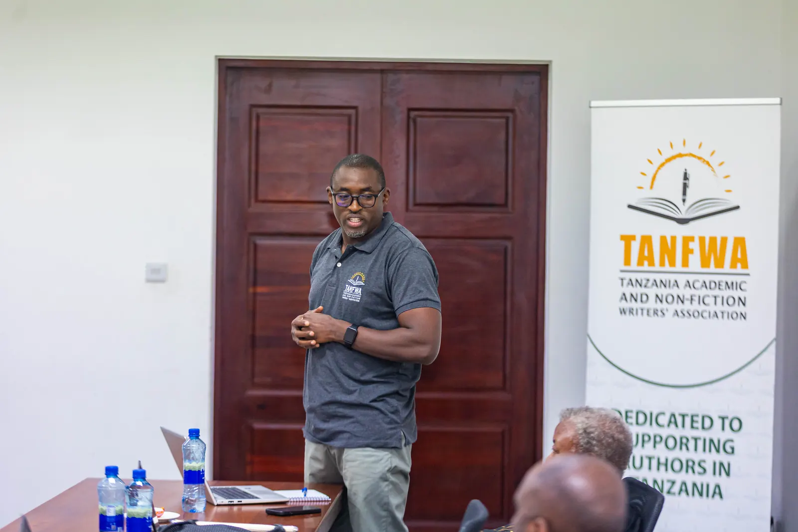 A TANFWA presenter speaking beside the TANFWA banner