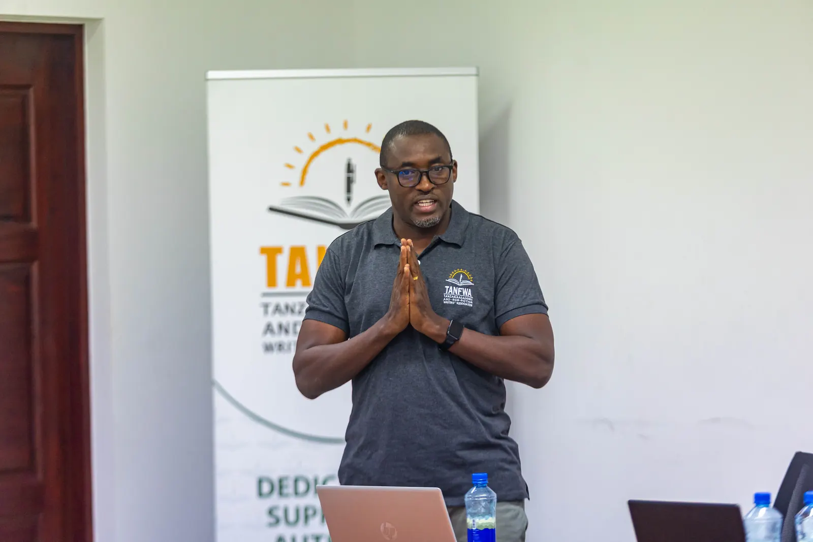 A TANFWA presenter addressing members beside the TANFWA banner